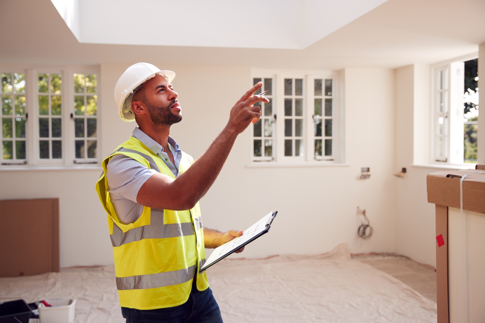 A man with a safety helmet is doing a new home inspection